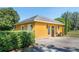 Exterior of a detached garage with a door, sconces, a small table and manicured hedges at 3020 Crews Lake Dr, Lakeland, FL 33813