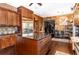 Open kitchen with granite island, stainless fridge, wooden cabinets, and hardwood flooring at 3020 Crews Lake Dr, Lakeland, FL 33813