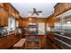 Gourmet kitchen featuring wood cabinetry, stainless steel appliances, an island, and dark hardwood floors at 3020 Crews Lake Dr, Lakeland, FL 33813