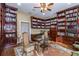 An elegant library showcasing custom bookshelves, a ceiling fan, and wood flooring at 3020 Crews Lake Dr, Lakeland, FL 33813