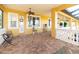 Inviting covered patio with brick floors, ceiling fan, and bright yellow walls offer a relaxing outdoor space at 3020 Crews Lake Dr, Lakeland, FL 33813