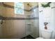 Well-lit walk-in shower with gray tile and glass door in a modern bathroom at 3176 Pearly Dr, Lakeland, FL 33812