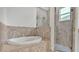 Modern bathroom showcasing a soaking tub and a glass-enclosed shower with decorative tile accents at 3176 Pearly Dr, Lakeland, FL 33812