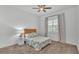 Inviting bedroom with a floral bedspread, bedside table, plantation shutters, and neutral carpet at 3176 Pearly Dr, Lakeland, FL 33812