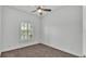 Minimalist bedroom featuring neutral carpet, a ceiling fan, a large window and electrical outlets at 3176 Pearly Dr, Lakeland, FL 33812
