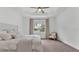 Cozy bedroom with soft carpet, tray ceiling, chair and window that provides natural light at 3176 Pearly Dr, Lakeland, FL 33812