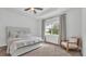 Calm bedroom with soft carpet, tray ceiling, and a comfortable window-side sitting area at 3176 Pearly Dr, Lakeland, FL 33812