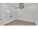 Bright bedroom featuring wood floors, white walls, a modern light fixture, and a window with white shutters at 3176 Pearly Dr, Lakeland, FL 33812
