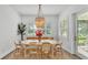 Well-lit dining area with a round table, rattan chairs, and a modern chandelier at 3176 Pearly Dr, Lakeland, FL 33812