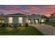 Charming gray home features well-manicured lawn, brick driveway, and beautiful dusk sky at 3176 Pearly Dr, Lakeland, FL 33812