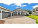Home showcasing a three-car garage and an expansive brick-paved driveway at 3176 Pearly Dr, Lakeland, FL 33812
