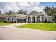 Charming front exterior with well-manicured lawn, columns, and attached two-car garage at 3176 Pearly Dr, Lakeland, FL 33812