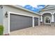 Attached three car garage featuring decorative carriage lamps at 3176 Pearly Dr, Lakeland, FL 33812