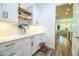 Open-concept kitchen with white cabinets, wood shelves, marble countertops and an adjacent dining area at 3176 Pearly Dr, Lakeland, FL 33812