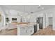 Open concept kitchen with island, white cabinets, stainless steel appliances, and hardwood floors at 3176 Pearly Dr, Lakeland, FL 33812
