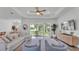 Open living room with a tray ceiling, neutral decor, and a large sliding glass door leading to the lanai at 3176 Pearly Dr, Lakeland, FL 33812