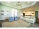 Open concept living room with a ceiling fan, wood floors, and natural light, next to the kitchen at 3176 Pearly Dr, Lakeland, FL 33812