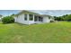 A well-maintained backyard with a lush green lawn, a screened-in porch, and white siding at 3618 Highland Fairways Blvd, Lakeland, FL 33810