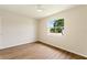Bedroom with wood-look floors, white walls, and large window at 3618 Highland Fairways Blvd, Lakeland, FL 33810
