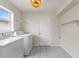 Bright laundry room with washer, dryer, storage shelves, and tiled flooring at 3618 Highland Fairways Blvd, Lakeland, FL 33810