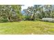 Expansive back yard showcasing lush green grass, mature trees, and partially fenced boundaries at 3829 Abbott Ln, Lakeland, FL 33810