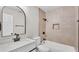 Bathroom with a tiled shower and tub, black fixtures, a white vanity, and a stylish round top mirror at 3829 Abbott Ln, Lakeland, FL 33810