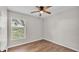 A bedroom featuring wood-look flooring, a ceiling fan, and a window bringing in natural light at 3829 Abbott Ln, Lakeland, FL 33810