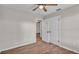 Bedroom featuring wood-look flooring, a ceiling fan, and two white doors for closet and bathroom access at 3829 Abbott Ln, Lakeland, FL 33810