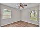 A bedroom featuring wood-look flooring, a ceiling fan, and windows bringing in natural light at 3829 Abbott Ln, Lakeland, FL 33810