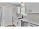 Kitchen featuring white cabinets, modern sink, and stainless dishwasher at 3829 Abbott Ln, Lakeland, FL 33810