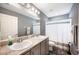 Bright bathroom with double sinks, gray cabinets, and shower curtain at 3883 Sandhill Crane Dr, Lakeland, FL 33811