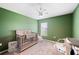 Cozy Bedroom features a ceiling fan, carpet, and baby furniture at 3883 Sandhill Crane Dr, Lakeland, FL 33811