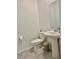 Clean half-bathroom with a pedestal sink, toilet, and stylish decor, offering convenience for guests at 3966 Willowbrook Dr, Edgewater, FL 32141