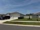 A single-story home featuring a well-manicured lawn, white exterior, and a three car garage at 3966 Willowbrook Dr, Edgewater, FL 32141