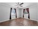 Bright bedroom with wood-look tile floors, modern ceiling fan, and two windows at 417 El Salvador Dr, Lakeland, FL 33809