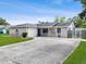 Appealing ranch-style home with a well-kept lawn, long driveway, and neutral gray color scheme at 417 El Salvador Dr, Lakeland, FL 33809