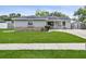 Inviting single-story home features a lush green lawn and attractive gray exterior with stone detail at 417 El Salvador Dr, Lakeland, FL 33809