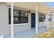 Charming front porch with white columns, blue door, and a rocking chair at 417 El Salvador Dr, Lakeland, FL 33809