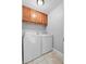 Cozy laundry room with appliances, upper cabinets, and tiled floor at 417 El Salvador Dr, Lakeland, FL 33809