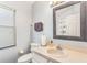 Bathroom featuring a well-lit mirror, toilet, sink, towel rack, and window at 436 Lady Diana Dr, Davenport, FL 33837