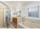 Bright bathroom featuring a shower, soaking tub, wood vanity, and vinyl flooring at 436 Lady Diana Dr, Davenport, FL 33837