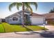 Beautiful single-story home with a well-manicured lawn and mature palm tree under a clear blue sky at 436 Lady Diana Dr, Davenport, FL 33837