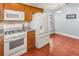 Bright kitchen featuring tile floors, wooden cabinets, granite countertops and white appliances at 436 Lady Diana Dr, Davenport, FL 33837
