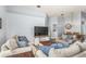 Bright living room featuring a large television, wood floors, and comfortable seating around a coffee table at 436 Lady Diana Dr, Davenport, FL 33837