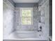 Bathroom featuring a tub, shower, window, tile walls, and tile flooring at 4808 Juliana Reserve Dr, Auburndale, FL 33823
