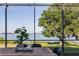 Covered outdoor dining area offers views of a mature tree, lush lawn, and a body of water at 4808 Juliana Reserve Dr, Auburndale, FL 33823