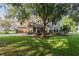 Traditional-style home featuring a lush lawn and a large mature tree shading the front at 4808 Juliana Reserve Dr, Auburndale, FL 33823