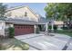 Charming home exterior featuring a large garage, manicured landscaping, and a welcoming front porch with stone accents at 4808 Juliana Reserve Dr, Auburndale, FL 33823