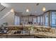 Open-concept kitchen with granite countertops that overlooks the living room with large windows and a fireplace at 4808 Juliana Reserve Dr, Auburndale, FL 33823