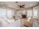 Open living room featuring neutral tones, a stone fireplace, built-in shelving, and a ceiling fan at 4808 Juliana Reserve Dr, Auburndale, FL 33823